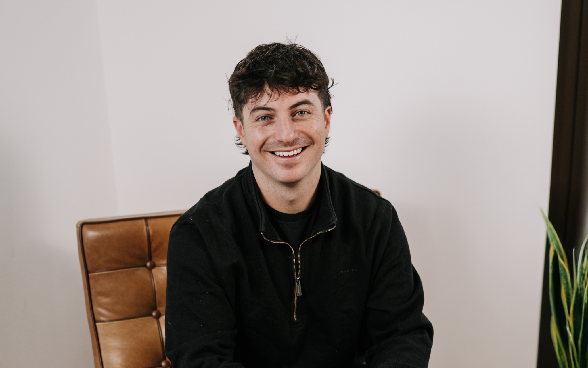 Kris Watt, Senior Recruiting Consultant, smiling and sitting on a chair.